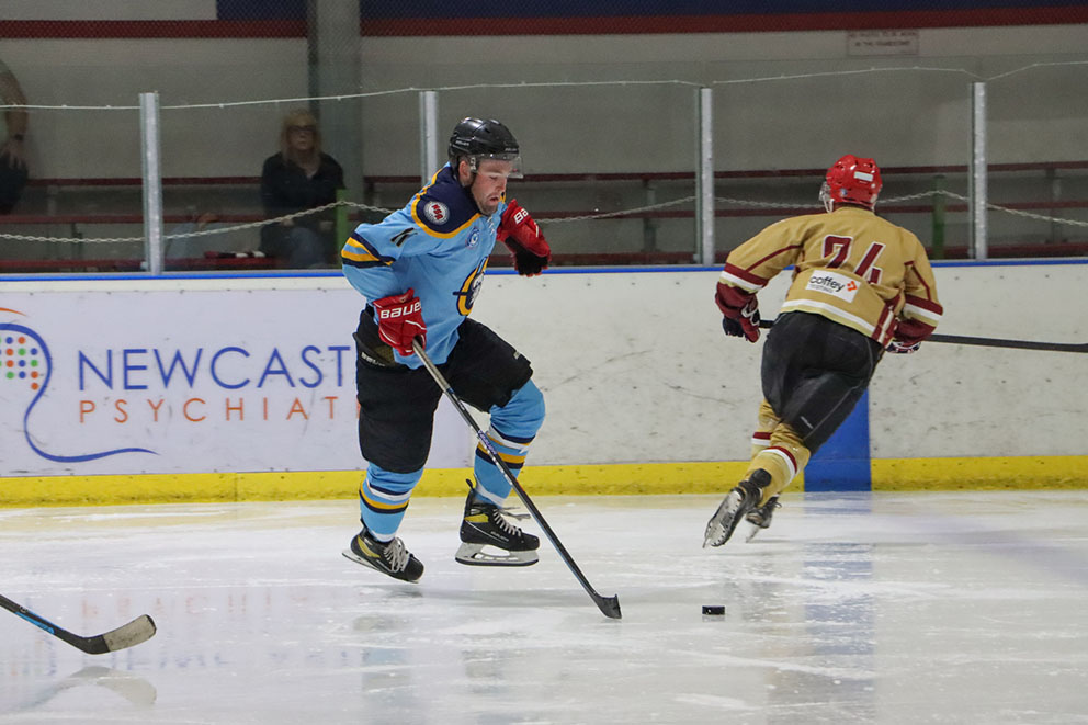 Liam Manwarring, playing for the Navigators in the Newcastle Ice Hockey League, plays the puck with his stick during a game.
