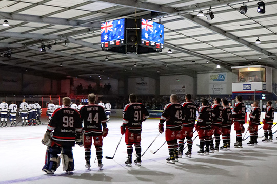 Newcastle Northstars players line up in their black alternate jerseys for the playing of the national anthem, while the Australian flag is show in the video screen at centre ice.