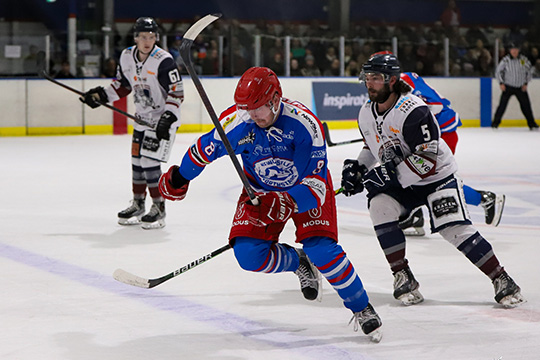 Newcastle Northstars player, Hamish Powell, skates hard to regain possession of the puck, while being pursued by Sydney Ice Dogs captain Daniel Patacky.