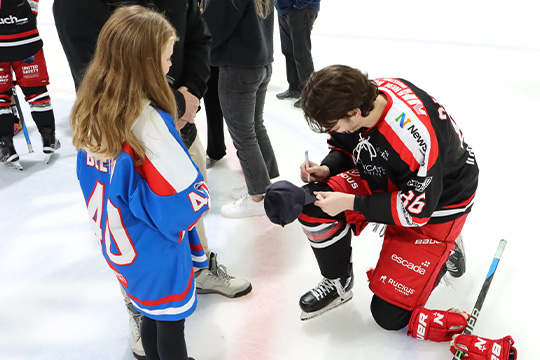 Newcastle Northstars forward, Mackenzie Gallagher, signs a hat for a young fan.