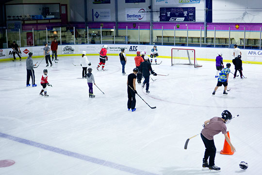 Participants receiving instruction at the Learn to Play hockey school.